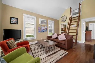 a living room with a couch and a tv at The Chicory - 4 Meadow View in Cherry Valley