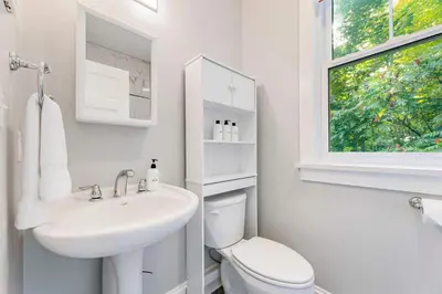 a bathroom with a sink and a toilet and a window at 5 Farm View in Cherry Valley