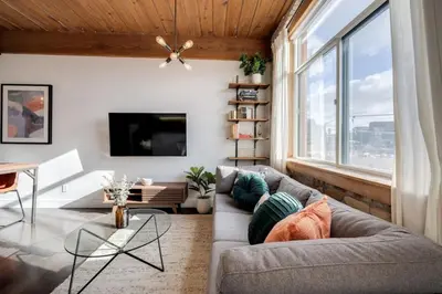 a living room with a couch and a large window at Downtown 1BR Modern Condo in Toronto