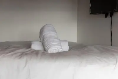 a stack of toilet paper sitting on top of a bed at Downtown 1BR Modern Condo in Toronto