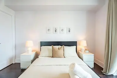 a bedroom with a large bed with two lamps at Luxury Condo with Pool, CN Tower View, Gym, Workspace in Toronto