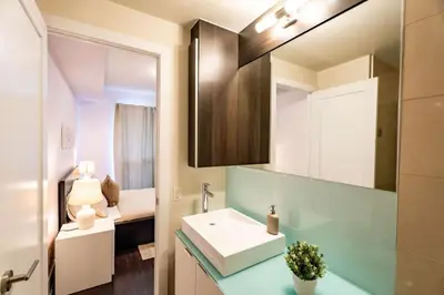 a bathroom with a sink and a mirror at Luxury Condo with Pool, CN Tower View, Gym, Workspace in Toronto
