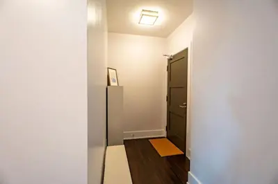 a hallway with a black refrigerator and a door at Luxury Condo with Pool, CN Tower View, Gym, Workspace in Toronto