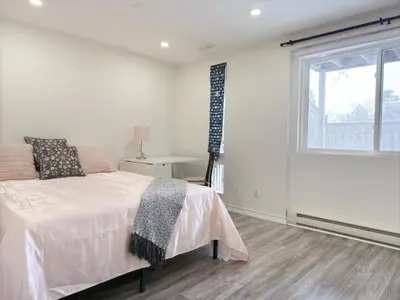 a white bedroom with a bed and a window at Cozy room with private bath near Don Mills Subway in Toronto