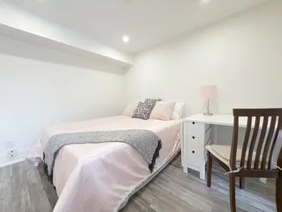 a bedroom with a bed and a desk and a chair at Cozy room with private bath near Don Mills Subway in Toronto