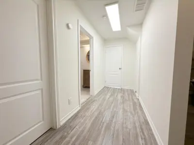 an empty hallway with white walls and wood floors at Cozy room with private bath near Don Mills Subway in Toronto