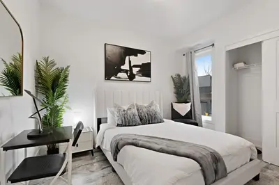a white bedroom with a large bed and a desk at NEW Stylish 2BR Suite With Sofa Bed, 7 Mins to Niagara Falls and Sleeps 6 in Niagara Falls