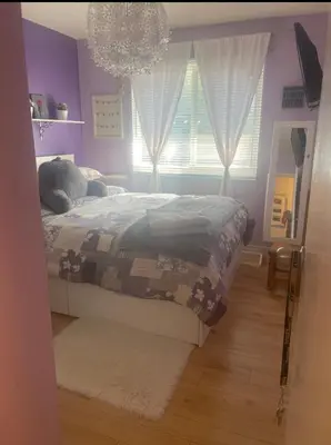 a bedroom with a bed and a window with a chandelier at Welcoming homestay with relaxing private room in Oakville