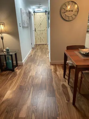 a hallway with wooden floors and a table and a clock at Welcoming homestay with relaxing private room in Oakville