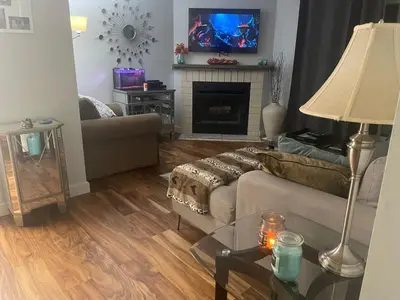 a living room with a couch and a fireplace at Welcoming homestay with relaxing private room in Oakville