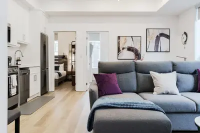 a living room with a blue couch and purple pillows at The McCaul by Casa Hotels - Modern Group Suite in Toronto