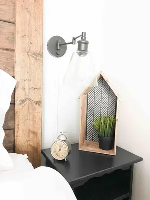 a clock and a lamp on a table next to a bed at Rustic Loft at Blue in Blue Mountains