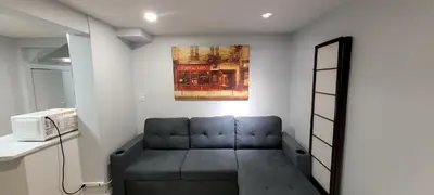 a living room with a couch and a microwave at Basement Studio in Brampton