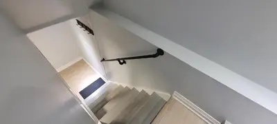 a staircase with white walls and a white stair case at Basement Studio in Brampton
