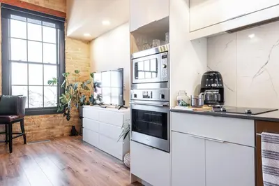a kitchen with white cabinets and a stove top oven at MR Loft formerly The Lehman Studio Stratford in Stratford