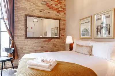 a bedroom with a large white bed and a brick wall at The Wallace Suite - Stratford in Stratford