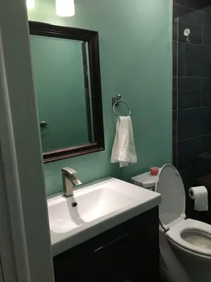 a bathroom with a sink and a toilet and a mirror at Splendid Modern Bungalow Suited For Big Groups in London
