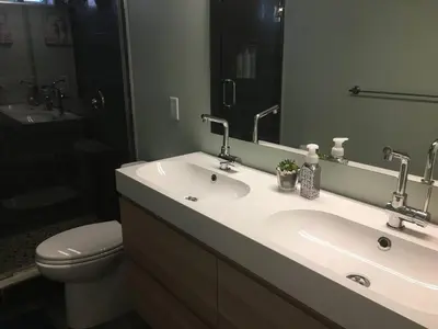 a bathroom with a sink and a toilet and a mirror at Splendid Modern Bungalow Suited For Big Groups in London