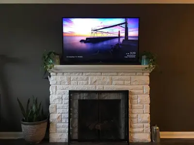 a flat screen tv sitting on top of a fireplace at Splendid Modern Bungalow Suited For Big Groups in London