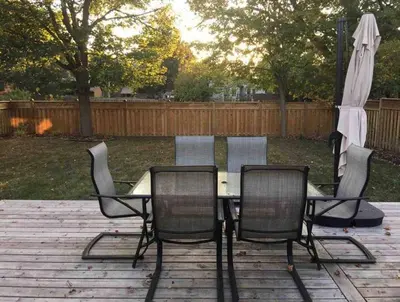 a table and chairs and an umbrella on a patio at Upscale 2-Bedroom Basement Apartment in London