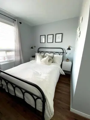 a bedroom with a large bed with white sheets and pillows at Beautiful Renovated Beach Cottage Home in Hamilton