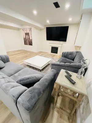 a living room with a couch and a tv at Modern Thorold Apt with Pool Table in Thorold