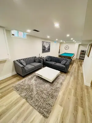 a living room with a couch and a table at Modern Thorold Apt with Pool Table in Thorold