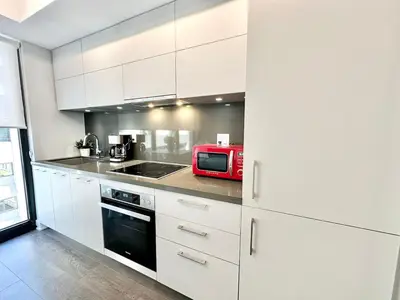 a kitchen with white cabinets and a red microwave at Condo in Yorkville - Newly Furnished Luxury Unit in Toronto
