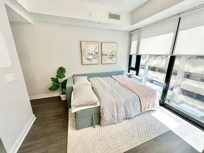a bedroom with a bed and a large window at Condo in Yorkville - Newly Furnished Luxury Unit in Toronto