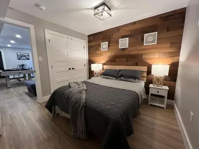 a bedroom with a bed with a wooden wall at The Luxe Lodge in Algonquin Highlands