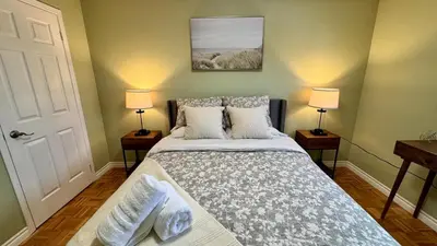 a bedroom with a bed with pillows and two lamps at Luxury Modern Retreat with Sauna & Modern Amenities in Mississauga