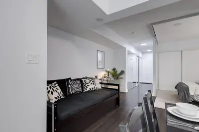 a living room with a black couch and a table at Exquisitely Furnished 1BR Suite in DWTN Toronto in Toronto