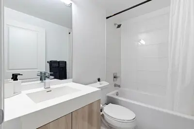 a white bathroom with a sink and a toilet at Downtown 2 bedroom Condo with Private Balcony in Toronto