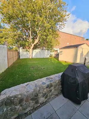 a black tarp on a stone wall in a yard at Spacious 2-bedroom ground floor unit near beach in Cobourg