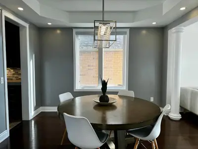a dining room with a table and white chairs at 3500 SqFt - Modern and Comfort - 4 BDRM Getaway - Relax - Unwind - Explore - Near Airport & Toronto Downtown in Brampton