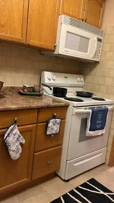 a kitchen with a stove and a microwave at Welcome to our cozy private Home in Pickering