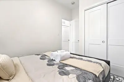 a white bedroom with a bed with towels on it at Cozy 2BR Suite with Parking & Close to Niagara Falls and Sleeps 6 Guests in Niagara Falls
