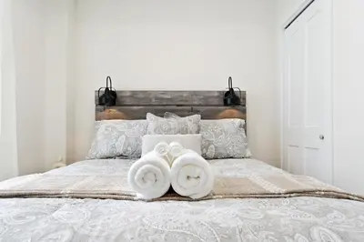 a bedroom with a bed with two towels on it at Cozy 2BR Suite with Parking & Close to Niagara Falls and Sleeps 6 Guests in Niagara Falls