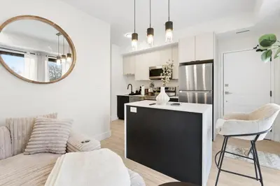 a kitchen and living room with a couch and a table at Cozy 2BR Suite with Parking & Close to Niagara Falls and Sleeps 6 Guests in Niagara Falls