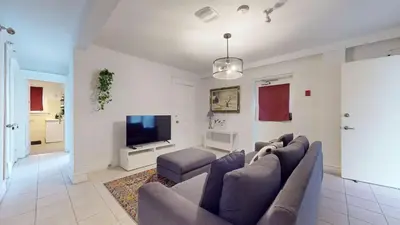 a living room with a couch and a flat screen tv at Comfortable & Spacious Private Room with Ensuite in Corso Italia in Toronto