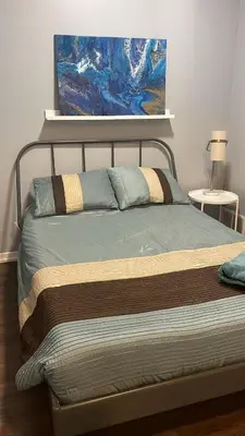 a bed in a bedroom with a painting on the wall at 1 BD and Den at Scotiabank Arena in Toronto