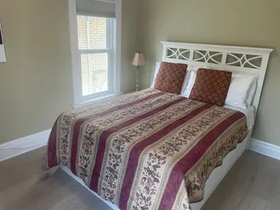 a bedroom with a large bed with a large window at Ultra Close to Clifton Hill and the Falls & Wonderful Free Breakfast Delivered Daily in Niagara Falls
