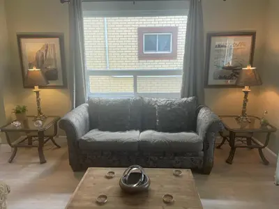a living room with a couch and a table at Ultra Close to Clifton Hill and the Falls & Wonderful Free Breakfast Delivered Daily in Niagara Falls