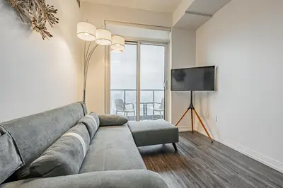 a living room with a couch and a flat screen tv at 2BR Condo close to Eaton Center in Toronto
