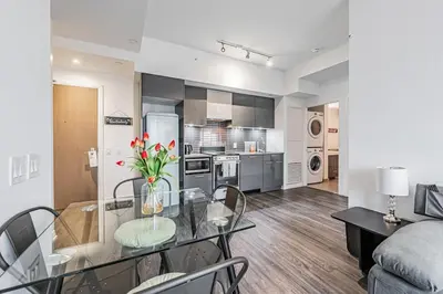 a kitchen and living room with a glass table and chairs at 2BR Condo close to Eaton Center in Toronto