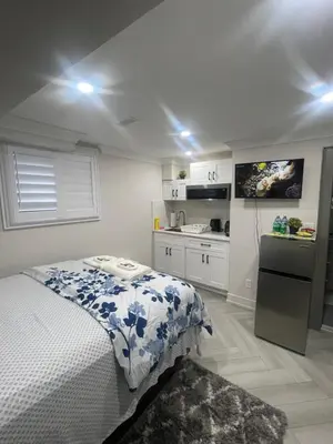 a small bedroom with a bed and a kitchen at Luxury Basement-Private Bdr & Bathroom with free parking In Toronto in Toronto