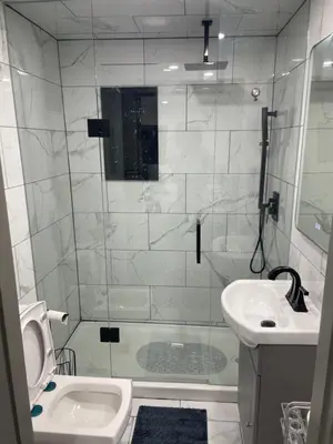 a white bathroom with a shower and a sink at Luxury Basement-Private Bdr & Bathroom with free parking In Toronto in Toronto