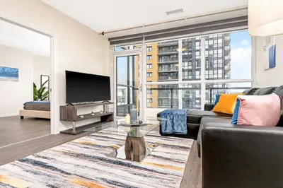 a living room with a couch and a tv at DT High Rise Condo w Private Patio and View in Kitchener