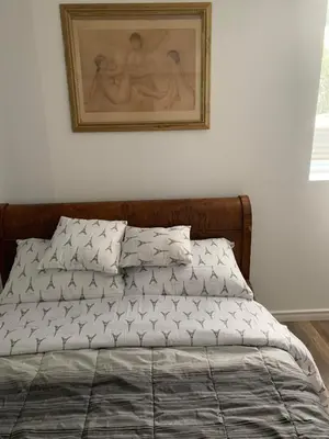 a bed in a bedroom with a picture on the wall at Two bedroom on Toronto Greenhills in Toronto