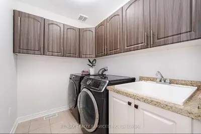 a kitchen with a washing machine and a sink at Beautiful 4 bed 3 master bedrooms-pvt washrooms in Brampton